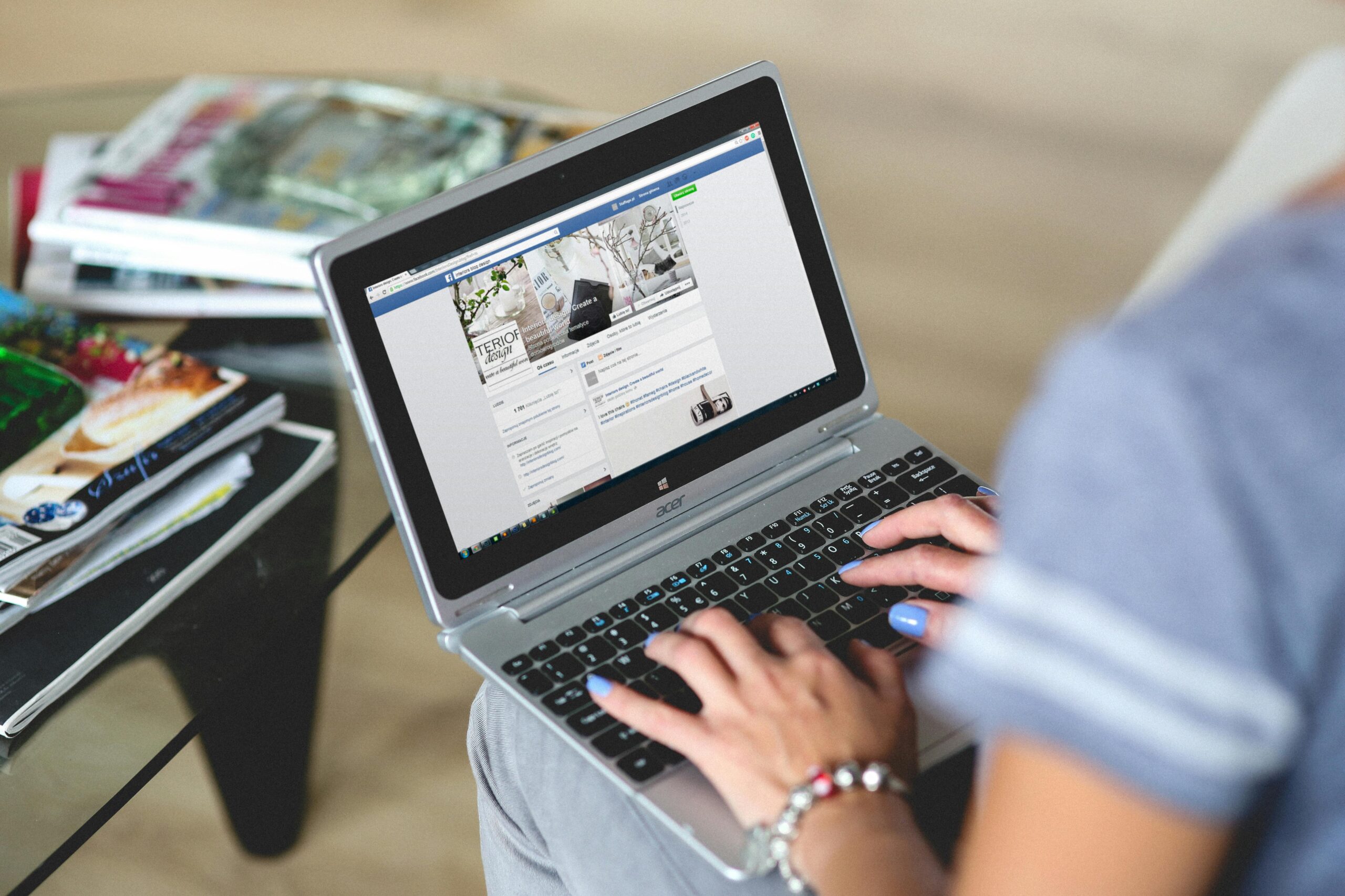 Woman browsing her Facebook feed on a desktop computer.